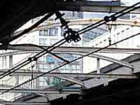 Gazing at the cables over the platform in South Gate of Shinjuku station surrounded by high-rise buildings.